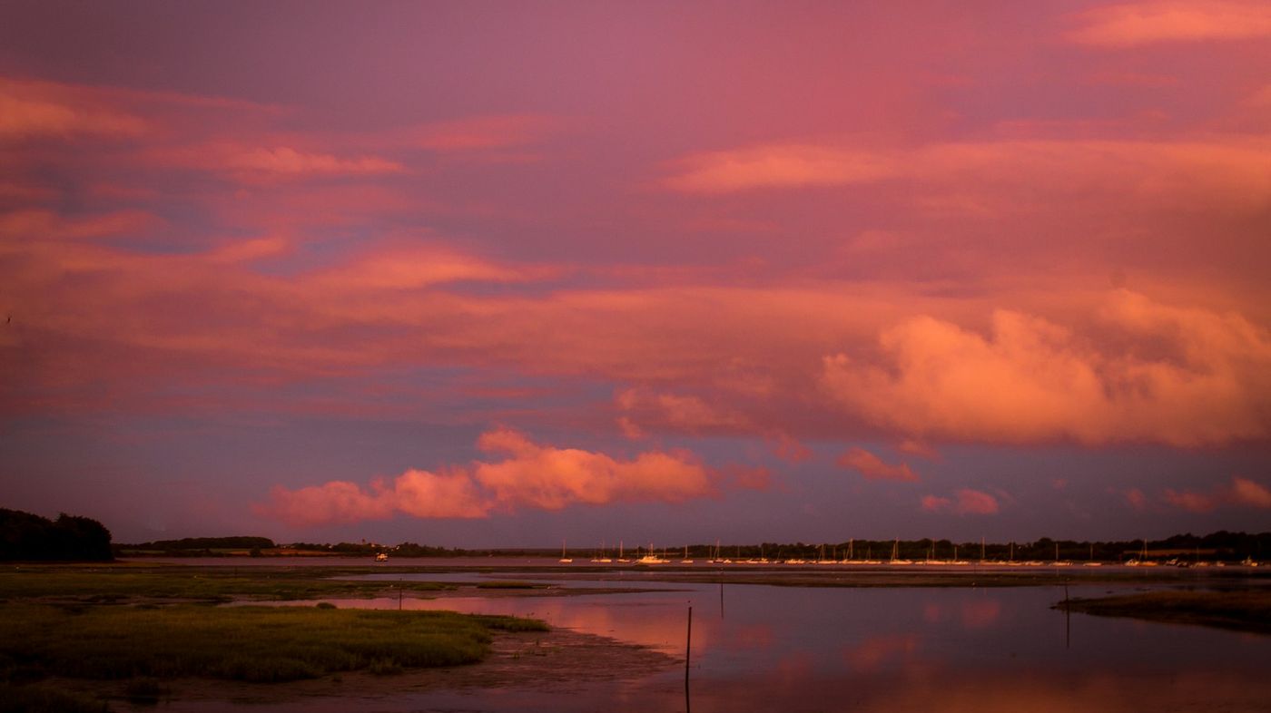 Ciel rose sur une étendue d'eau calme au crépuscule, l'esprit des étangs autour de Guerlesquin