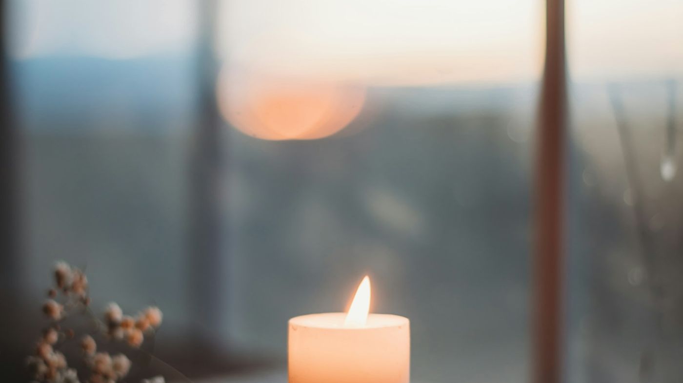 Une bougie et une fenêtre floue, l'ambiance feutrée d'une séance de thérapie près de Lanmeur