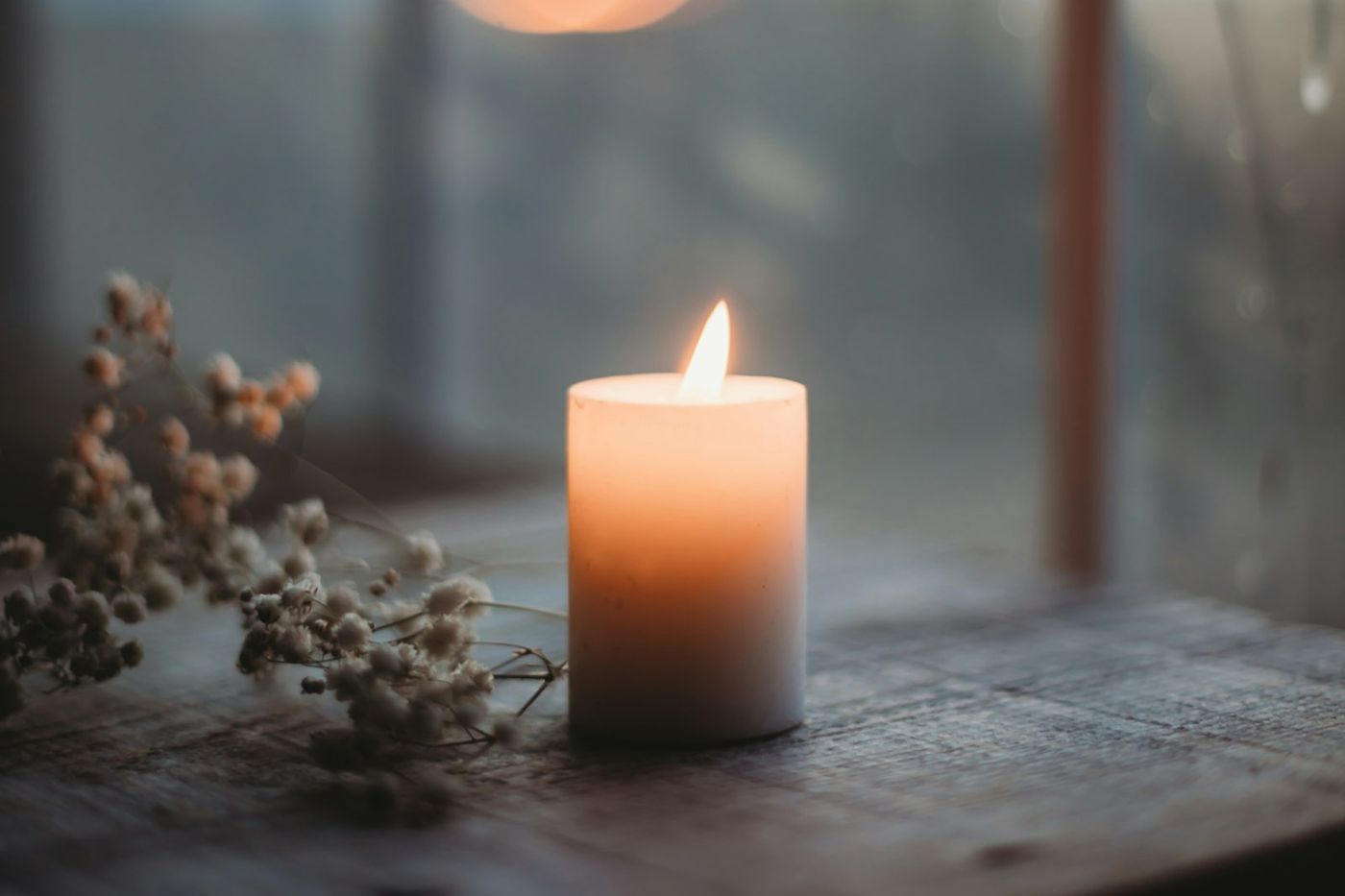 Une bougie allumée près d'une fenêtre, comme le calme d'une séance de thérapie à Plestin-les-Grèves
