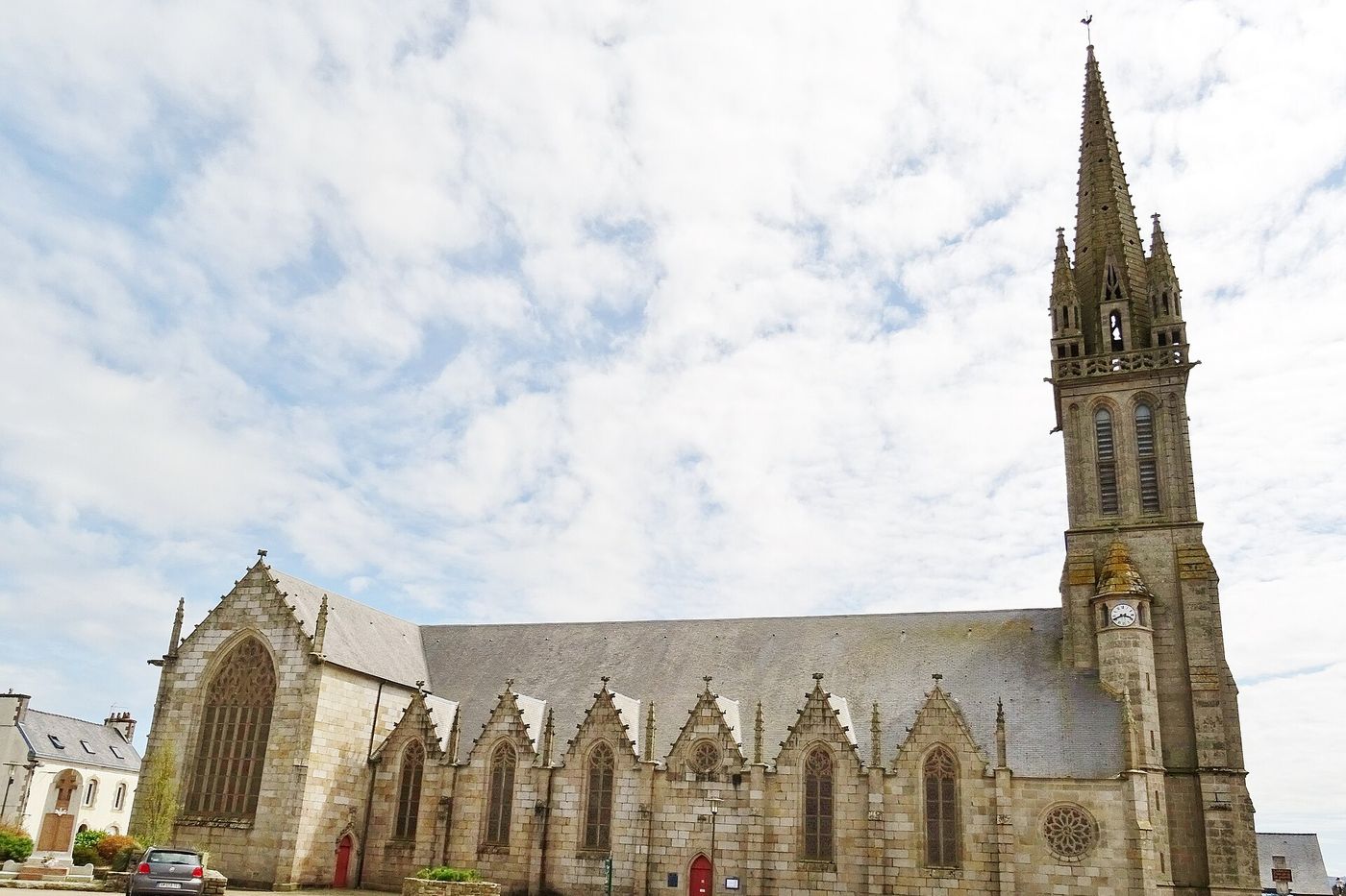 L'église de Plouigneau, sa nef de granite et son haut clocher à flèche, au cœur du bourg