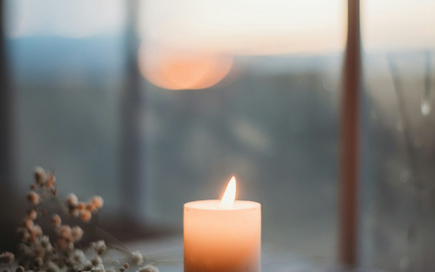 Une bougie allumée devant une fenêtre, la lumière douce d'une séance pour sortir d'une impasse, près de Plourin-lès-Morlaix
