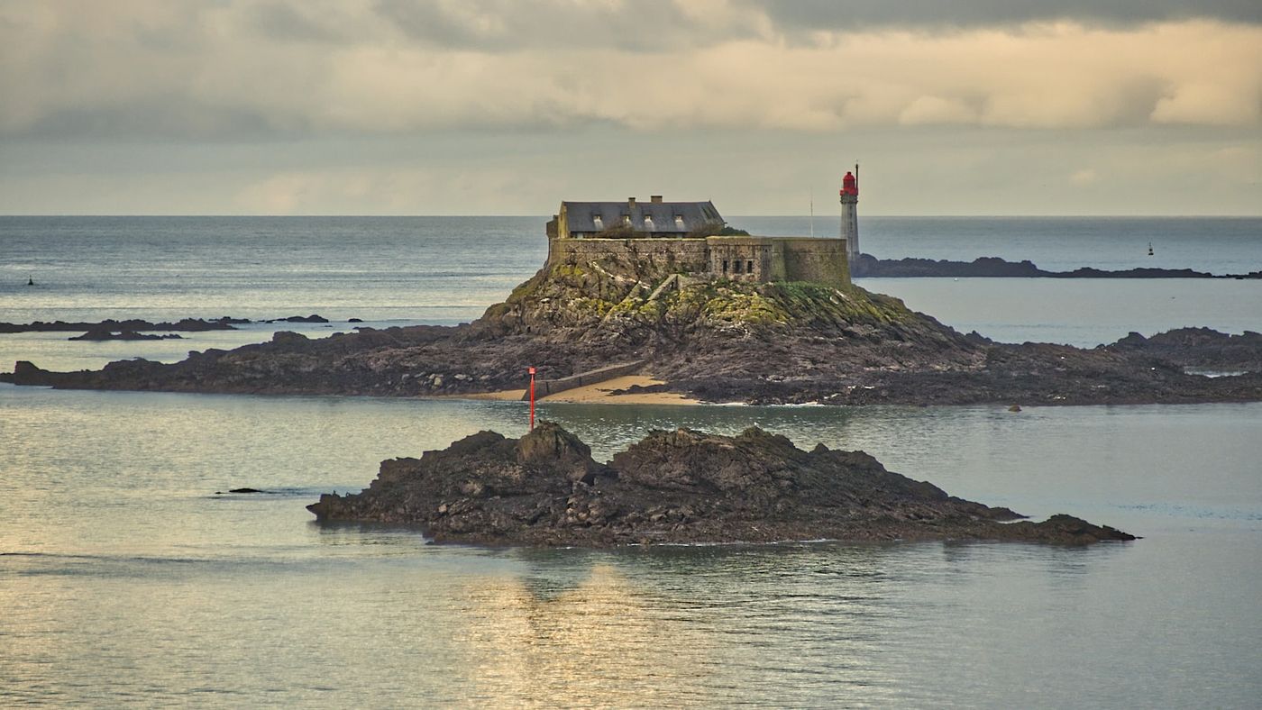 Îlots rocheux et petit fort dans une baie calme de la côte bretonne, un horizon dégagé comme près de Saint-Michel-en-Grève