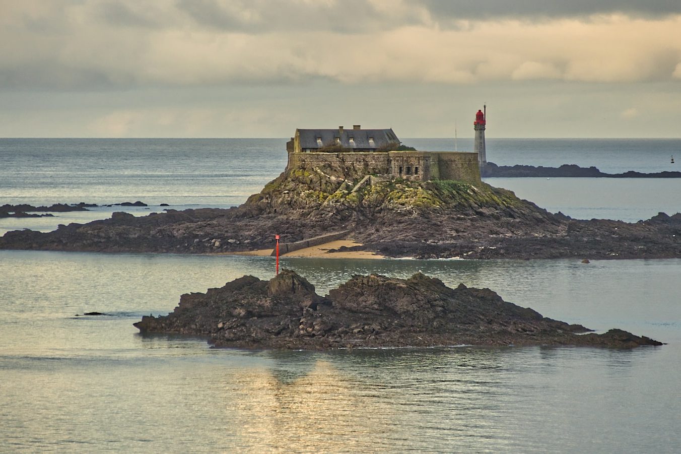 Îlot rocheux et mer calme à la lumière du soir, comme l'horizon que l'on contemple depuis Trébeurden