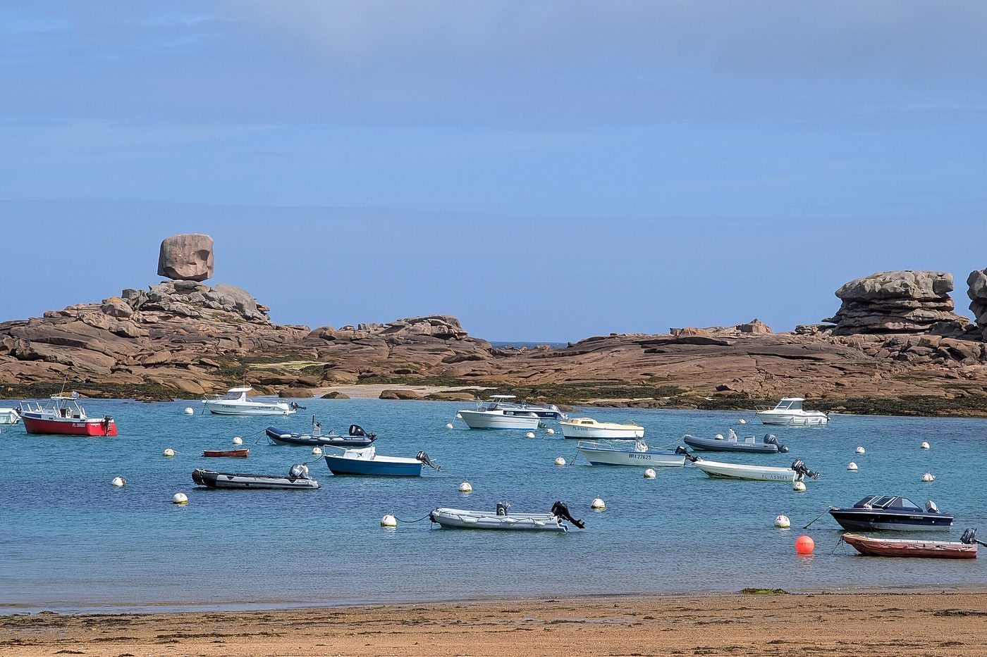 Blocs de granit rose et barques au mouillage dans la baie de Coz Pors, à Trégastel