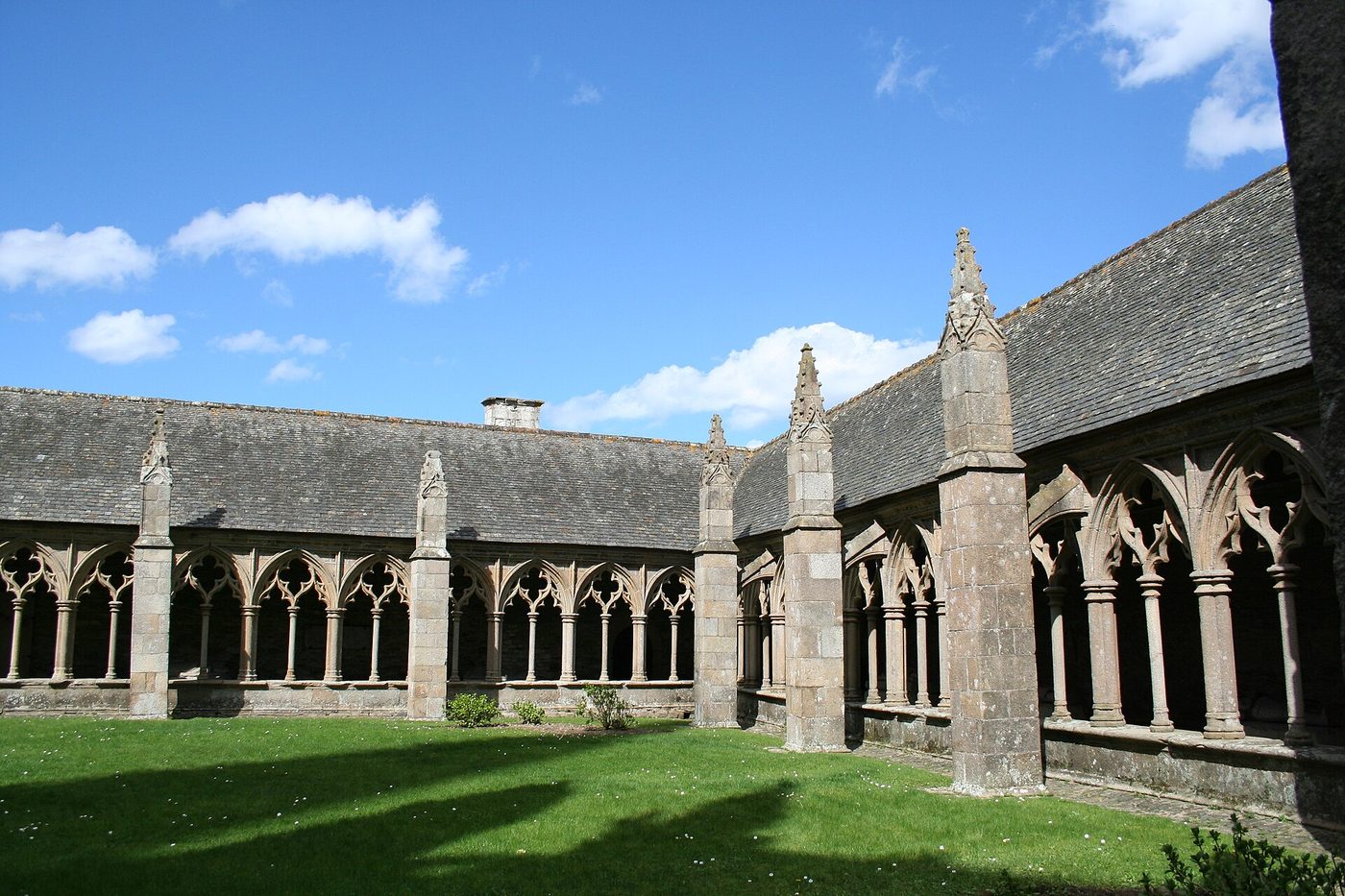 Galeries gothiques du cloître de la cathédrale Saint-Tugdual autour d'une pelouse, à Tréguier